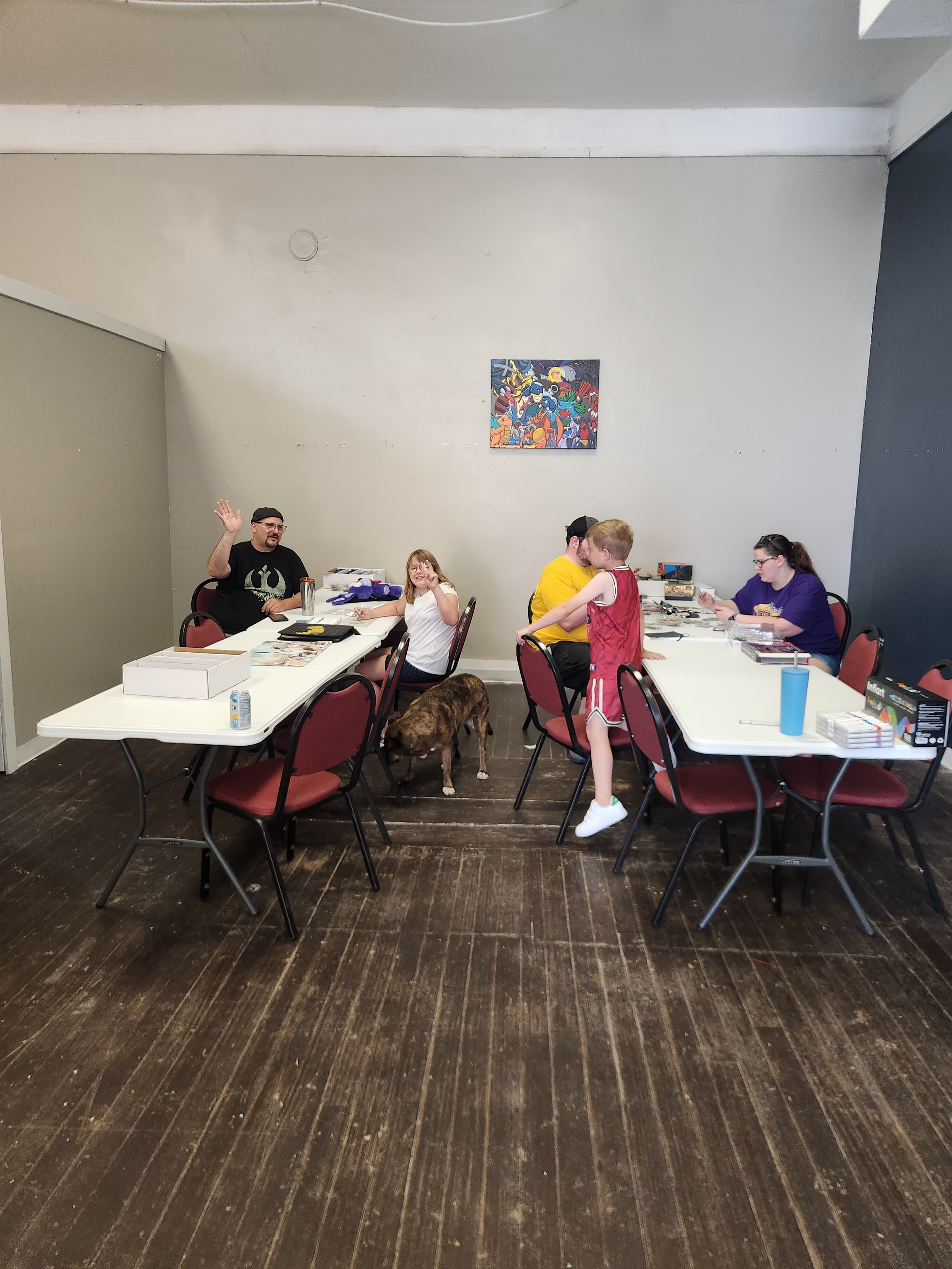 Players hanging out and playing cards together at The Wolf Den tables